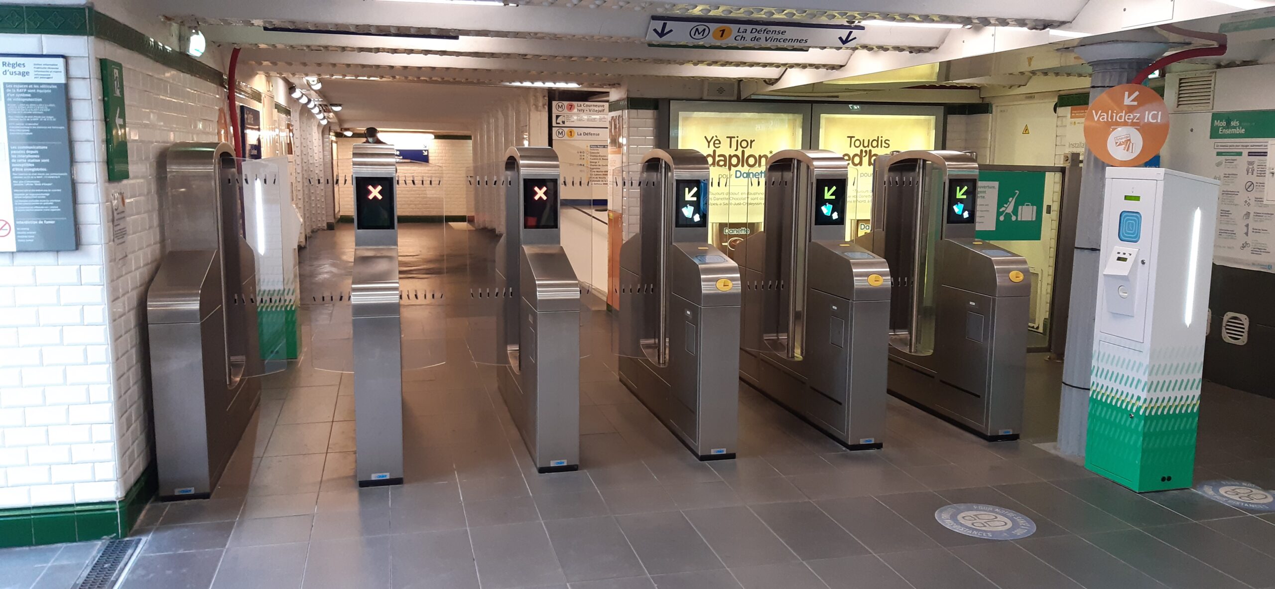 Intérieur d'une station de transport avec portes automatiques en verre et signalétique jaune
